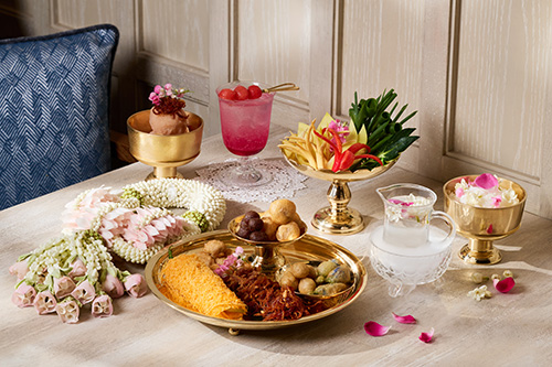 ชุดสำรับ ข้าวแช่ สีทองงดงามพร้อมเครื่องเคียงดั้งเดิมและเครื่องดื่มคลายร้อน ณ ห้องอาหารเดอะ สยาม ที รูมท์ โรงแรมแบงค็อก แมริออท มาร์คีส์ ควีนส์ปาร์ค